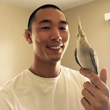 BJJ student David Yu with his pet bird sitting on his finger