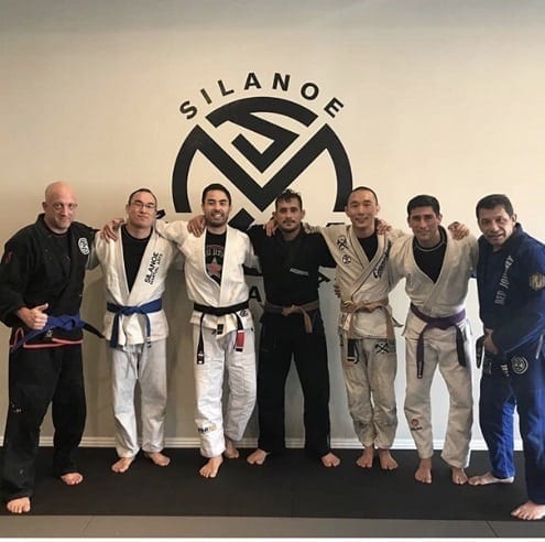 A group picture in front of the wall with Dan Kang Professor Gino teammates and friends from Texas